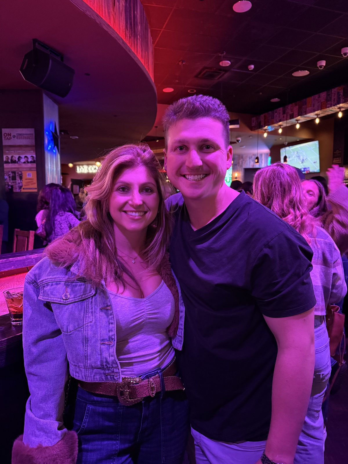 Smiling together at a neon-lit bar