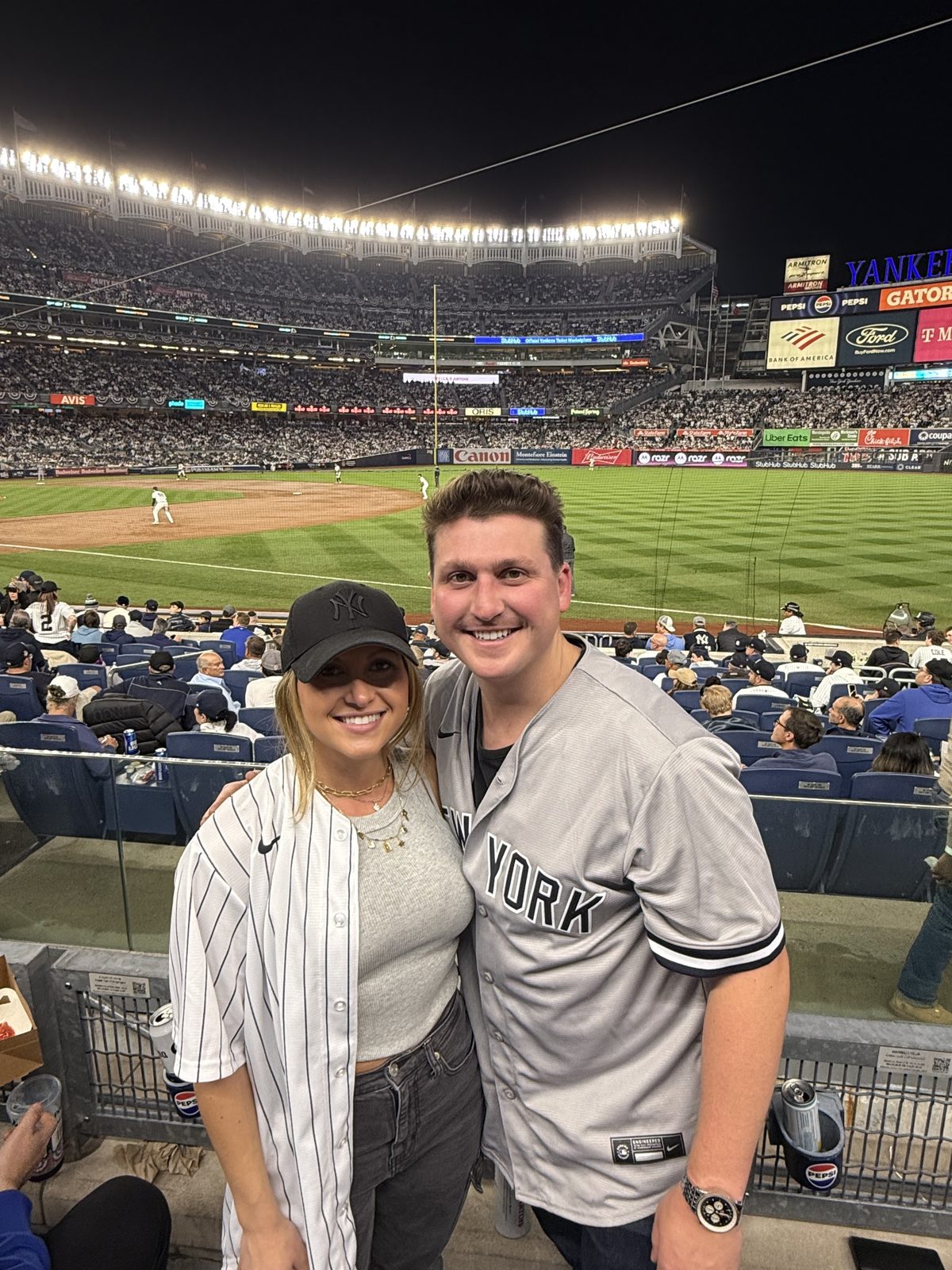 At a night game at Yankee Stadium with the field behind them